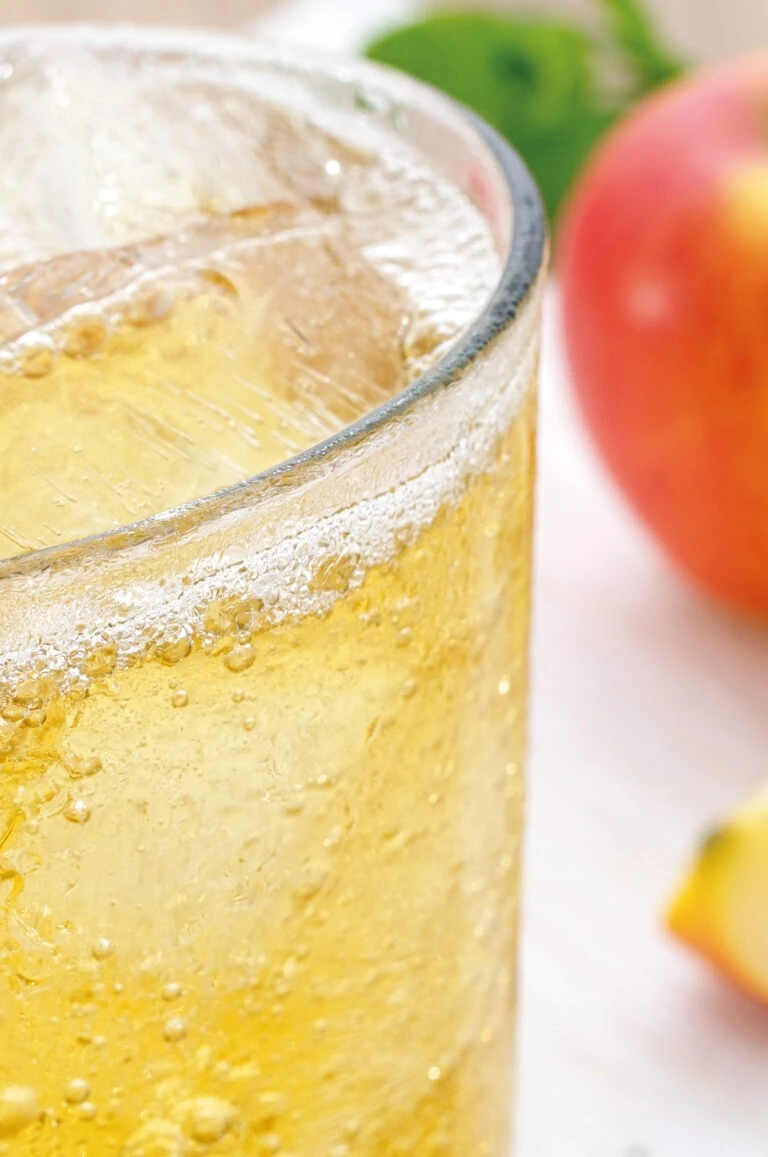 Verre de cocktail pétillant à base de cidre, avec une pomme